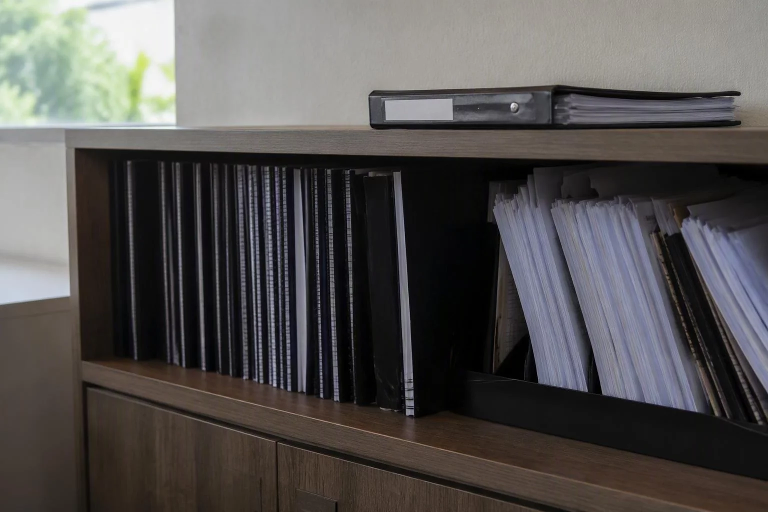 Prateleira com manuais encadernados e fichas de auditoria